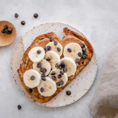 Tostada con mantequilla de maní, plátano en rodajas y chispas de chocolate. ¡Perfecta para merendar!