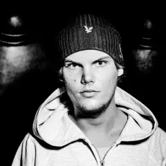 Avicii, młody mężczyzna w czapce z daszkiem i bluzie z kapturem, patrzy prosto w obiektyw.