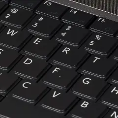Zbliżenie na klawiaturę laptopa z widocznymi klawiszami QWERTY. Różne rodzaje klawiatur w telefonie mogą przypominać ten układ.