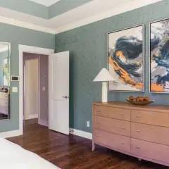 A tall dresser with a lamp, fruit bowl, and vase offers elegant tall dresser decor ideas.