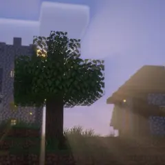 Wioska w Minecraft z vanilla plus shaders. Słońce przebija się przez drzewa, oświetlając kamienne domy i wieżę.