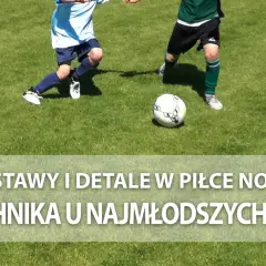 Dwóch młodych piłkarzy ćwiczy podanie w piłce nożnej na zielonej murawie.