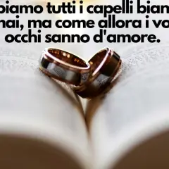 Due fedi nuziali su un libro aperto, simbolo di un amore che dura. Buon primo anniversario di matrimonio!