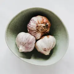 Czosnek w misce, symbol domowych sposobów na katar u dziecka. Naturalne wsparcie dla malucha.
