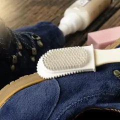 Pflege für deine leguano schuhe: Blaue Wildlederschuhe werden mit einer Bürste und Pflegeprodukten gereinigt.