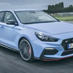 Un Hyundai i30 N azul compite en una pista, mostrando su potente motor y diseño deportivo.