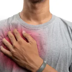 Uomo con mano sul petto, evidenziando un'area arrossata che suggerisce prurito al petto uomo.
