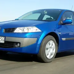 Niebieski Renault Megane 2 1.6 16v w ruchu, z widoczną tablicą rejestracyjną WE 0725G.