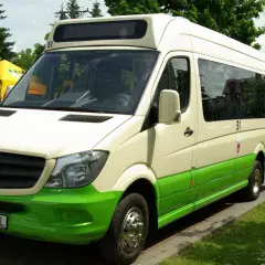 Biało-zielony bus Mercedes-Benz z numerem 51 na dachu, zaparkowany na zewnątrz.