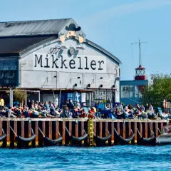 Menschen genießen das Kopenhagen Essen und Craft Beer am Kai vor dem Mikkeller Gebäude.