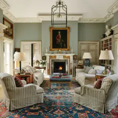 Elegant living room with fireplace, portraits, and plush seating, showcasing the expertise of home design consultants.