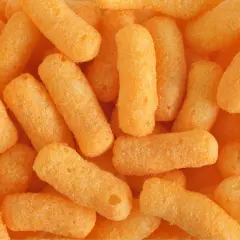 Zbliżenie na stos chrupek kukurydzianych w kolorze pomarańczowym.
