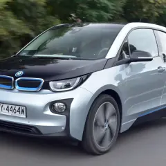 Srebrno-czarny BMW i3, elektryczny samochód, jedzie po drodze.