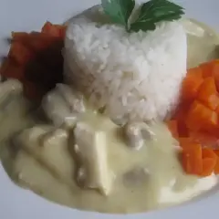 Ryż z kawałkami kurczaka w kremowym sosie potrawkowym, podany z marchewką.