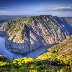Majestuoso río serpentea entre escarpados acantilados cubiertos de vegetación, creando un paisaje impresionante en los cañones del Sil.