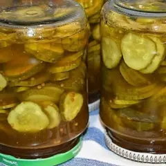 Słoiki pełne plasterków ogórków w zalewie z przyprawami, gotowe do podania jako dodatek do dań. Te ogórki w curry z pewnością dodadzą smaku!
