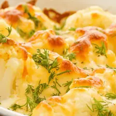 Coliflor al horno gratinada con queso y hierbas frescas. Un plato reconfortante y delicioso.