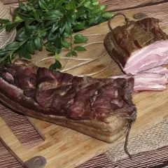 Dwa kawałki wędzonego boczku na desce. Zastanawiasz się, czym natrzeć boczek do wędzenia? Ten wygląda apetycznie!