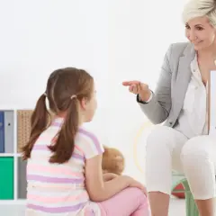 Nauczycielka pokazuje dziecku literę "A" z jabłuszkiem. To ważne znaki ostrzegawcze dla dzieci, które uczą się liter.