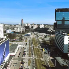 Widok na nowoczesne centrum Katowic z wieżowcami i drogą w tle.