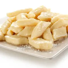 Pyszne leniwe pierogi na talerzu. Idealne co na obiad dla dzieci, posypane cukrem pudrem.