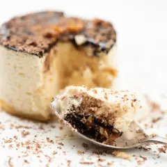 Un cucchiaino raccoglie un pezzo di delizioso parfait, con strati di crema e cioccolato, cos'è questa bontà?