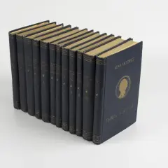 Zbiór dzieł Adama Mickiewicza, tom 11, w ciemnogranatowej oprawie. Pozostałe tomy tworzą tło, sugerując bogactwo jego biografii i twórczości.