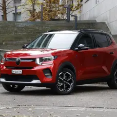 Czerwony Citroen EC3 z czarnym dachem stoi na tle betonowych schodów.
