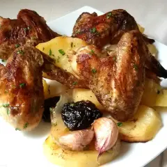 Alitas al horno con patatas, ajo y ciruelas pasas. Un plato casero y delicioso.