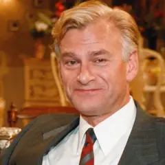 Peder Falk, en man med grånande hår och en vänlig blick, sitter i en elegant miljö.