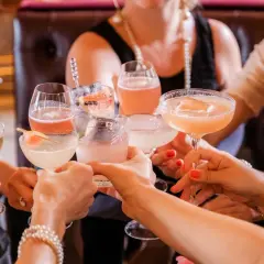 Kobiety wznoszą toast kolorowymi drinkami. Zastanawiasz się, ile kalorii ma drink?