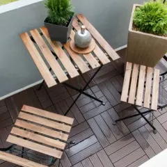 Drewniane deski na balkonie, idealne jako czym wyłożyć balkon. Stolik i krzesła zapraszają do odpoczynku wśród zieleni.