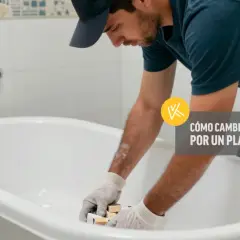 Un hombre con guantes trabaja en una bañera, preparándose para cambiarla por un plato de ducha.