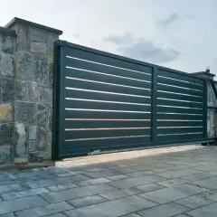 Nowoczesna brama przesuwna na kamiennym murze. Czy ogrodzenie można odliczyć od podatku?