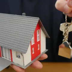 Model domu i klucze z breloczkiem w kształcie domu. Kluczowe dokumenty do odbioru domu.