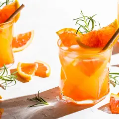 Erfrischender Aperitif mit Prosecco, Orangenstücken und Rosmarin. Perfekt für einen sonnigen Nachmittag.