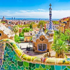 Kolorowa mozaika i budynki w Parku Güell w Barcelonie z widokiem na miasto.