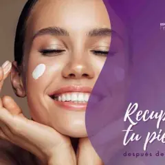 Mujer sonriente con crema en la mejilla, disfrutando de los beneficios de una limpieza facial para recuperar su piel después del verano.