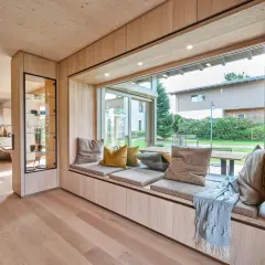 Gemütliche **Ideen für Sitzfenster**: Ein einladender Bereich mit Kissen und Decke lädt zum Verweilen ein, während der Blick ins Grüne schweift.