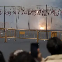 El estruendo de la mascletà hoy llena el aire de humo y chispas. Cuerdas de petardos cuelgan, esperando el momento de explotar.
