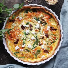 En gyllene, smakrik vegetarisk paj med spenat, soltorkade tomater och pinjenötter. Perfekt för en mysig middag.