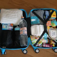 Walizka z rzeczami dla dziecka na podróż samolotem Ryanair: ubranka, pieluchy, zabawki, chusteczki, żel antybakteryjny i jedzenie dla dziecka.