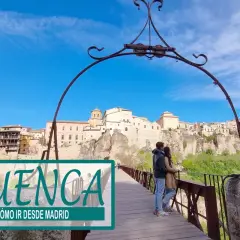 Pareja en puente de madera con vistas a la ciudad de Cuenca, un destino ideal para una escapada desde Madrid.