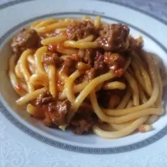 Pici fatti in casa conditi con un ricco ragù di carne, un classico della cucina toscana.