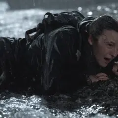 Ellie, wyczerpana i przemoczona, czołga się po kamieniach. To trudne zakończenie The Last of Us 2.
