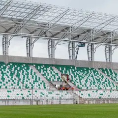Stadion Radomiaka w budowie. Zielono-białe trybuny czekają na kibiców, a pracownicy montują dach.