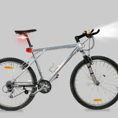Silver mountainbike med fram- och bakljus samt ringklocka. All cykel utrustning är på plats för en säker tur.
