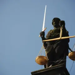 Temida z mieczem i wagą symbolizuje sprawiedliwość. Zastanawiasz się, ile bierze komornik za alimenty? Prawo jest po Twojej stronie.