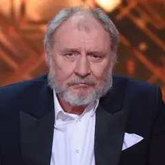 Andrzej Grabowski, znany z roli Ferdynanda Kiepskiego, w eleganckim garniturze. Jego wiek dodaje mu powagi.