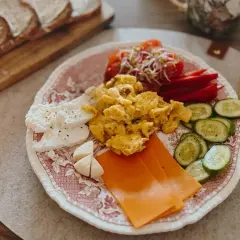 Szybkie zdrowe śniadanie: jajecznica, ser, pomidory, ogórek i pieczywo. Idealny start dnia!